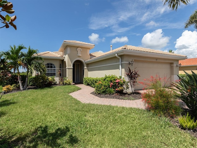 mediterranean / spanish house featuring a front yard and a garage