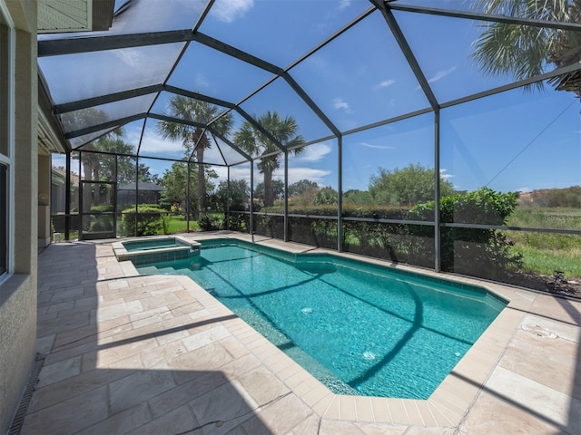 view of swimming pool with glass enclosure, an in ground hot tub, and a patio