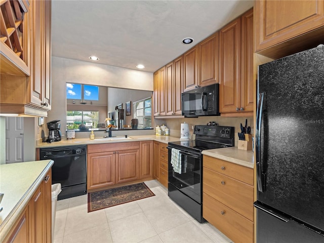 kitchen with black appliances, light tile patterned flooring, and sink