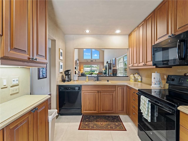 kitchen with black appliances, light tile patterned flooring, and sink