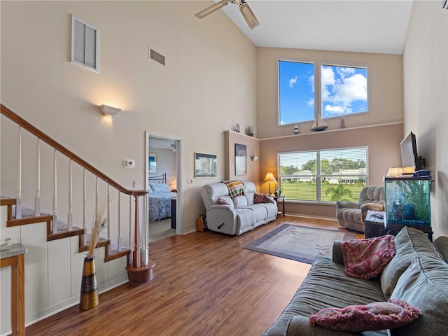 living room featuring a healthy amount of sunlight, hardwood / wood-style floors, ceiling fan, and high vaulted ceiling