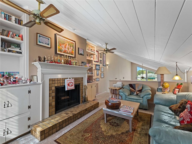 carpeted living room featuring a tile fireplace, lofted ceiling, wood ceiling, and ceiling fan