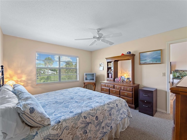 carpeted bedroom with a textured ceiling and ceiling fan