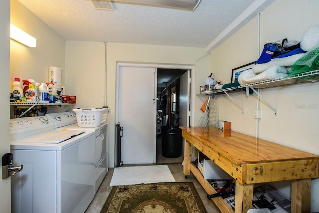 laundry room with a textured ceiling and washing machine and clothes dryer