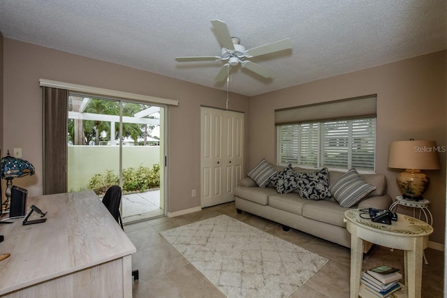 tiled office space featuring ceiling fan and a textured ceiling