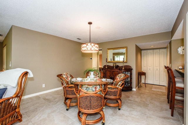 dining area featuring light tile patterned floors and a textured ceiling