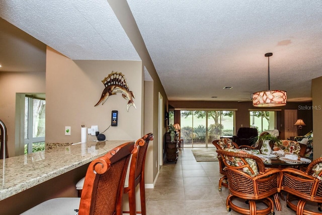 tiled dining space with a textured ceiling