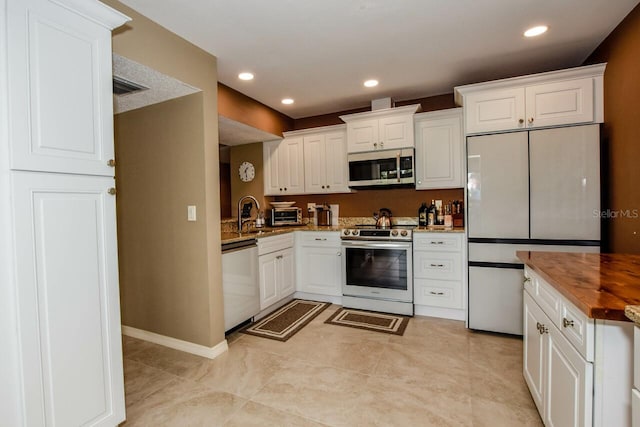 kitchen featuring white cabinets, butcher block countertops, and stainless steel appliances