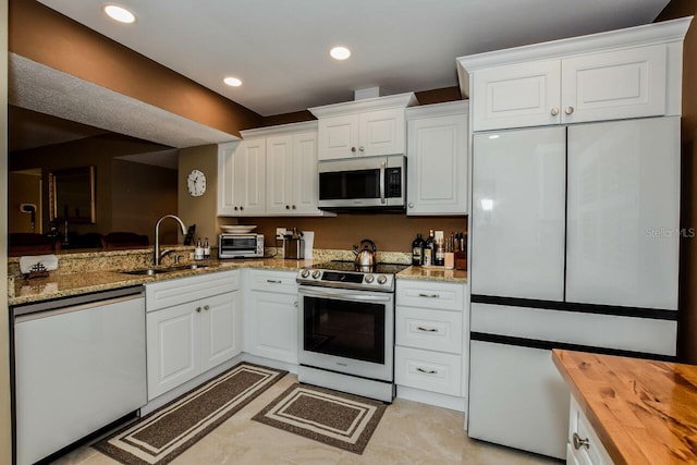 kitchen with white cabinetry, wooden counters, and stainless steel appliances