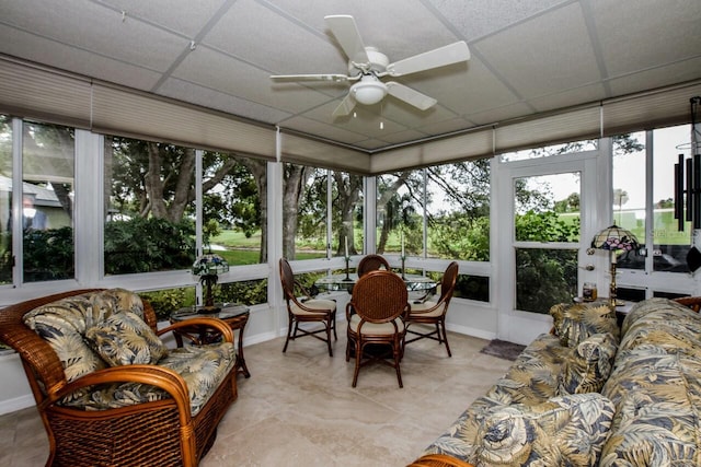 sunroom / solarium featuring a drop ceiling and ceiling fan