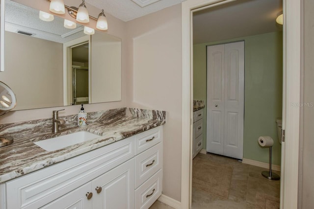 bathroom featuring tile patterned floors, vanity, a textured ceiling, and walk in shower