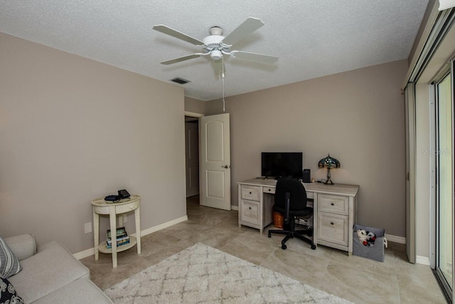 office featuring ceiling fan, light tile patterned floors, and a textured ceiling