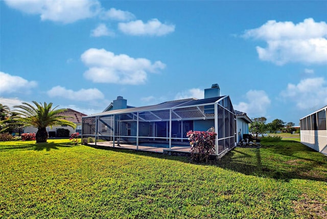 rear view of house with a pool, a lawn, a lanai, and a patio area