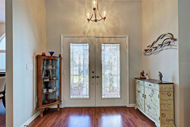 entrance foyer with dark hardwood / wood-style floors, french doors, and a notable chandelier