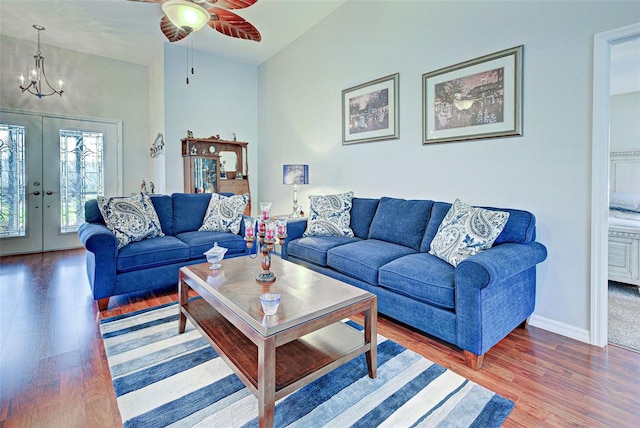 living room featuring ceiling fan with notable chandelier, high vaulted ceiling, french doors, and hardwood / wood-style flooring