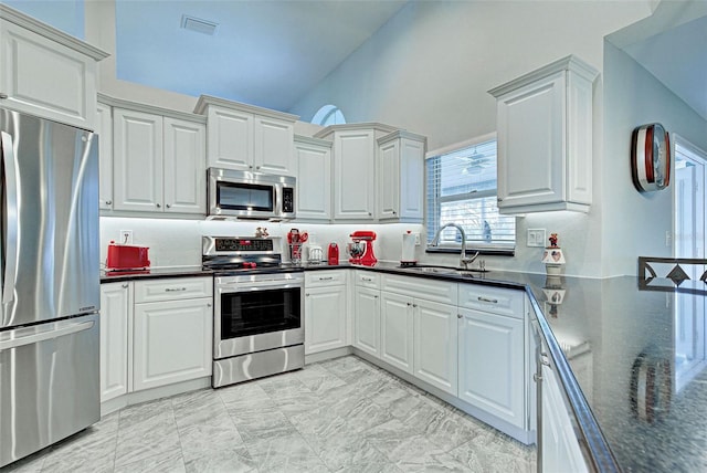 kitchen with white cabinetry, sink, stainless steel appliances, and high vaulted ceiling