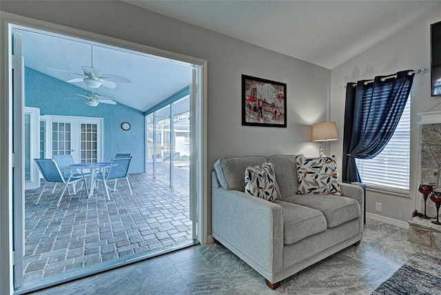 living room with ceiling fan, plenty of natural light, and vaulted ceiling