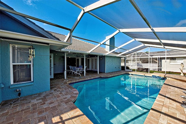 view of swimming pool featuring a lanai and a patio area