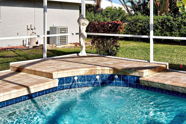 view of pool with a yard, central air condition unit, and pool water feature