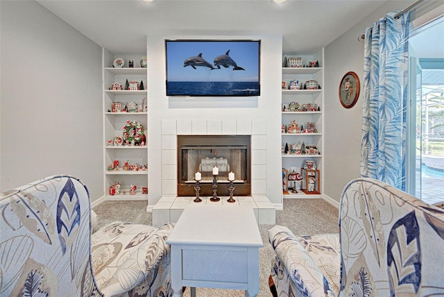 living room featuring a tile fireplace and carpet