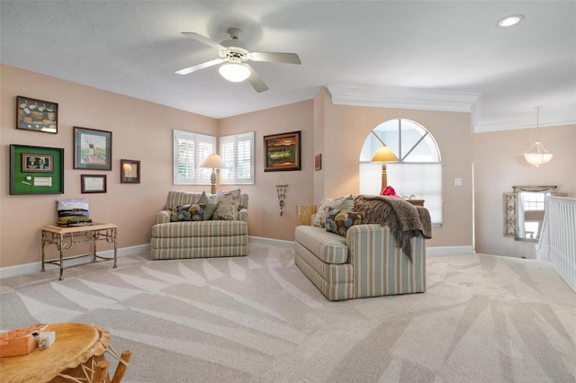 living room with ornamental molding, ceiling fan, and light colored carpet