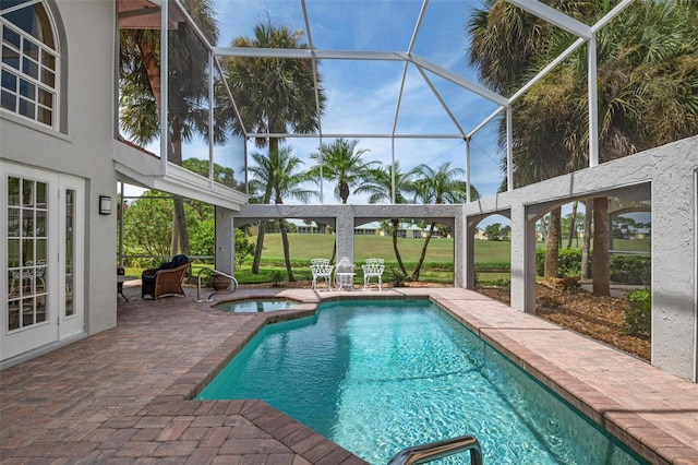 view of pool featuring a lawn, a patio, glass enclosure, and an in ground hot tub