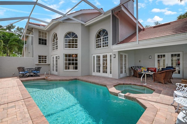 exterior space with french doors, a lanai, a patio area, and an in ground hot tub