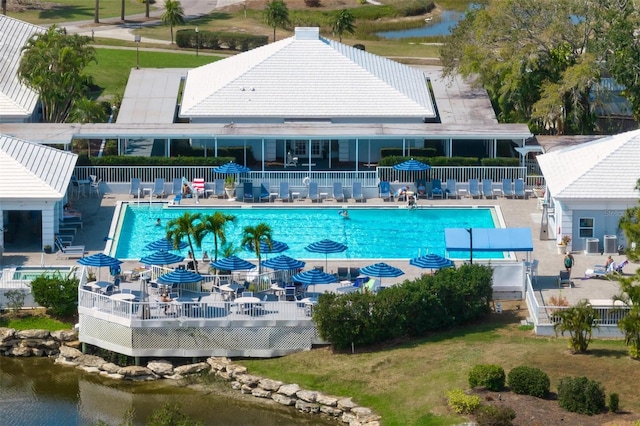 view of swimming pool featuring a water view and a patio area