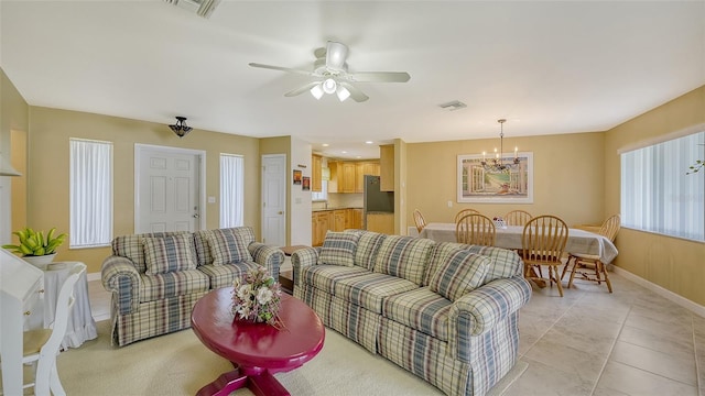 living room featuring ceiling fan with notable chandelier and light tile patterned floors