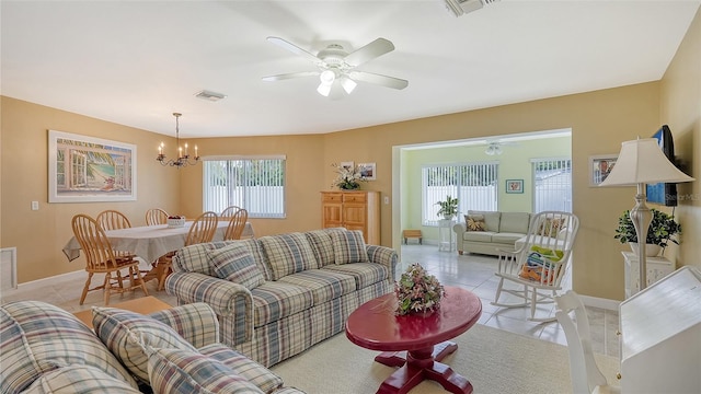 tiled living room with ceiling fan with notable chandelier