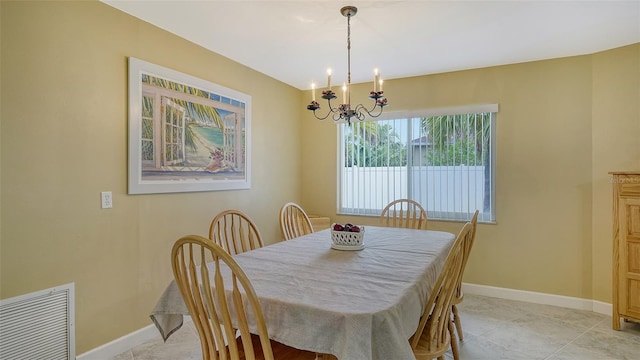 tiled dining room featuring an inviting chandelier