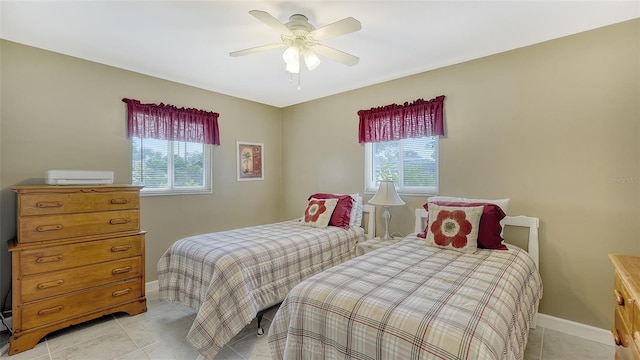 tiled bedroom featuring ceiling fan and multiple windows