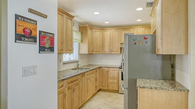 kitchen with light brown cabinets, appliances with stainless steel finishes, and sink