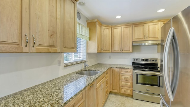 kitchen featuring light stone countertops, stainless steel appliances, light brown cabinetry, and sink