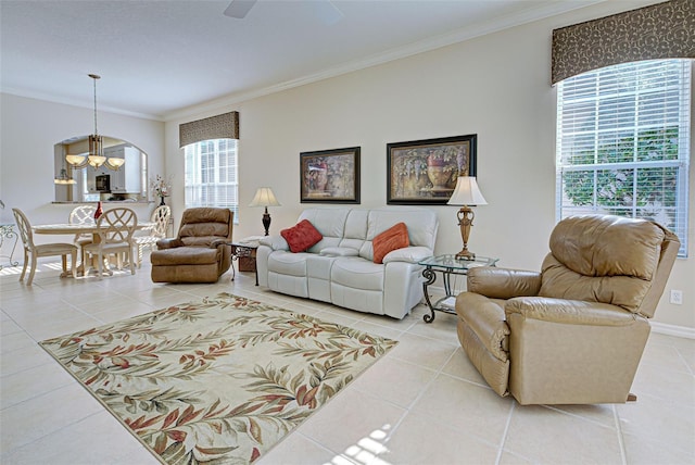 tiled living room with ceiling fan with notable chandelier, a healthy amount of sunlight, and ornamental molding