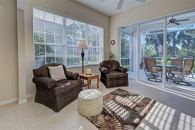 living area with tile patterned floors, ceiling fan, and a healthy amount of sunlight