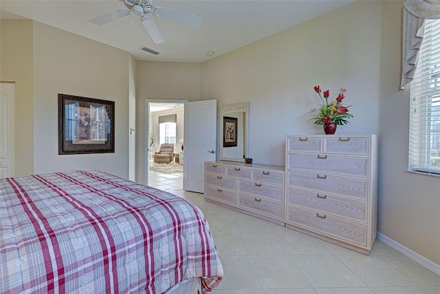 bedroom featuring multiple windows, ceiling fan, and light tile patterned floors