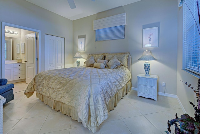 bedroom with ceiling fan, light tile patterned floors, connected bathroom, and a closet