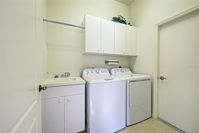 washroom with sink, light tile patterned floors, cabinets, and independent washer and dryer