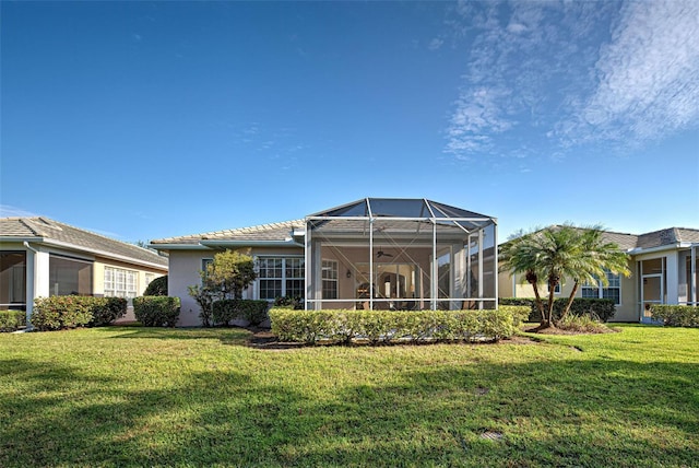 back of property with a lawn and a lanai