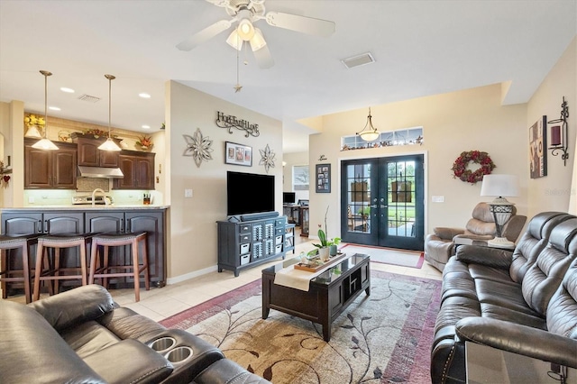 tiled living room with french doors, sink, and ceiling fan