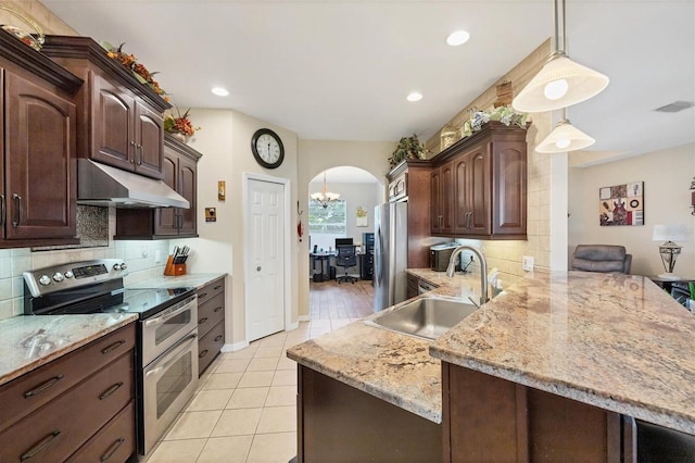 kitchen featuring dark brown cabinets, sink, kitchen peninsula, stainless steel appliances, and decorative light fixtures