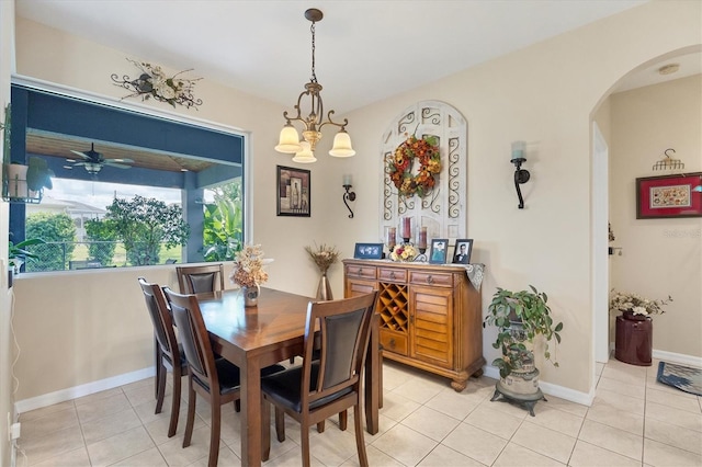 tiled dining area with ceiling fan with notable chandelier