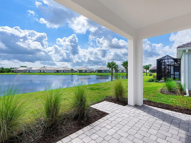 view of patio with a water view and a lanai