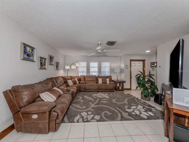 living room featuring ceiling fan, a textured ceiling, and light tile patterned flooring