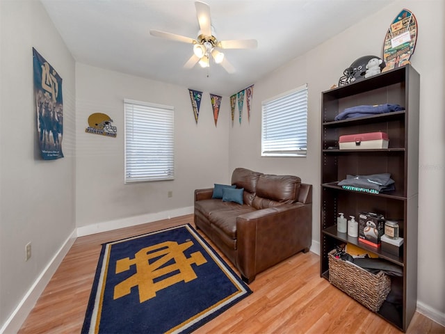 living area featuring hardwood / wood-style floors and ceiling fan