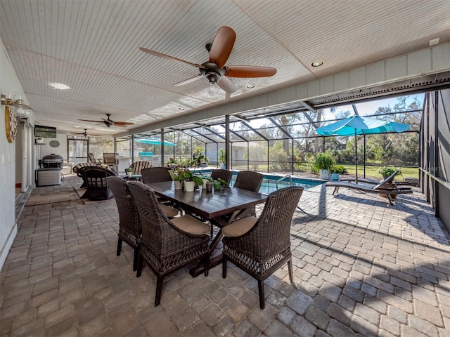 sunroom / solarium with a swimming pool and ceiling fan