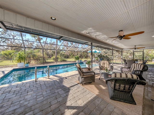 view of swimming pool featuring a patio area, ceiling fan, and glass enclosure