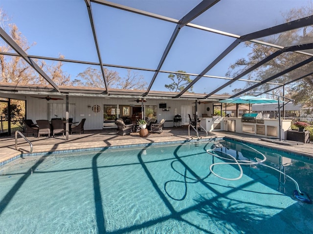 view of pool with a patio area, area for grilling, ceiling fan, and glass enclosure