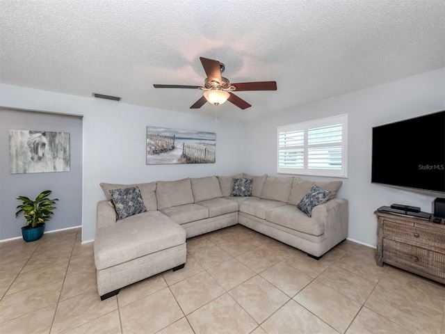 living room with a textured ceiling, light tile patterned flooring, and ceiling fan